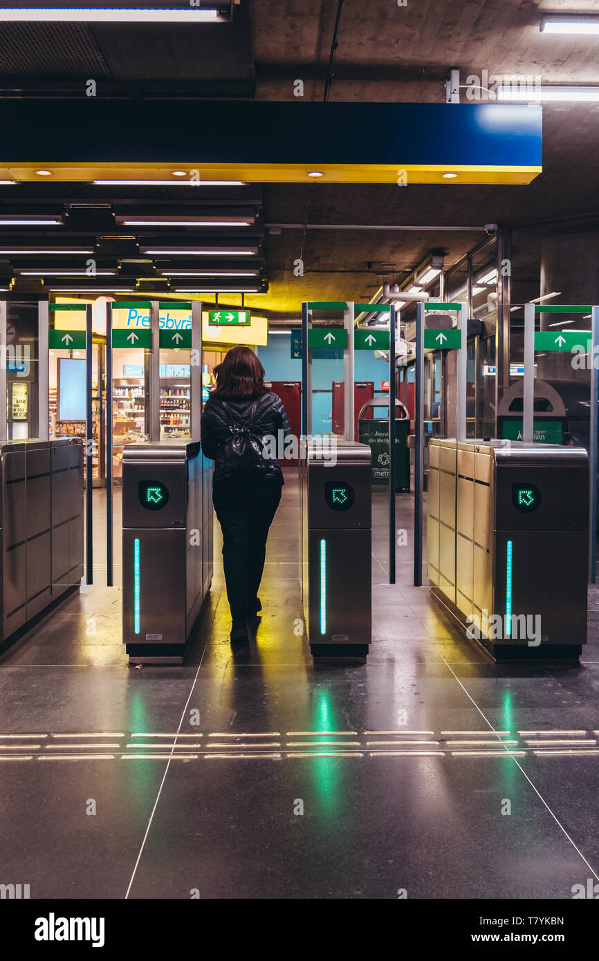 Editorial 03.27.2019 Stockholm Sweden. Woman walking out from the subway platform thought the baffle gates at the station Stock Photo
