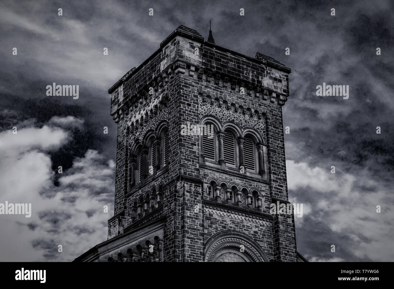Old gothic tower in front of cloudy blue sky. Stock Photo