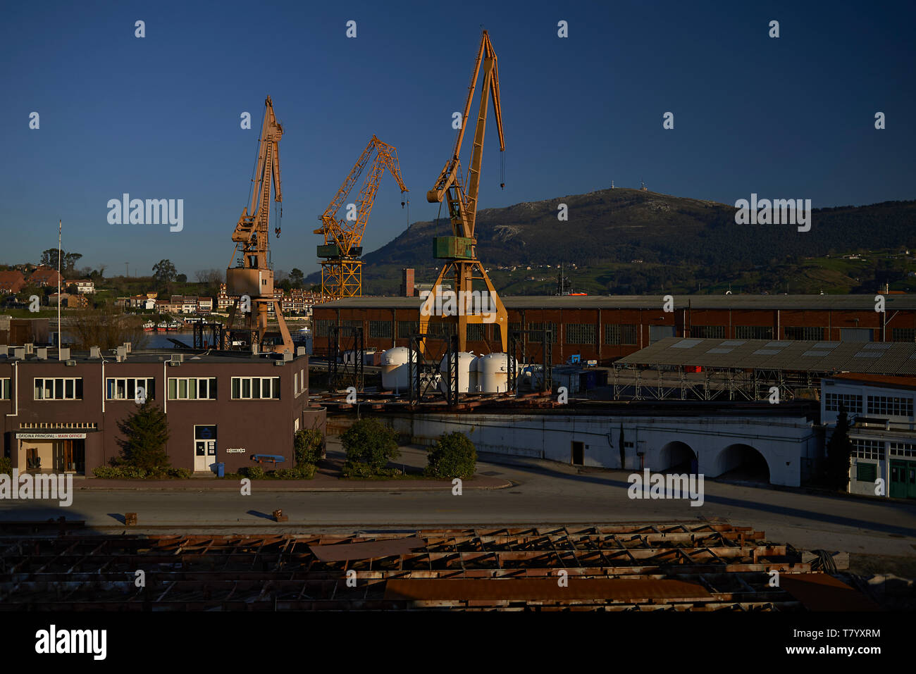 Shipyard with cranes and a newly constructed ship in summer sunshine Stock Photo