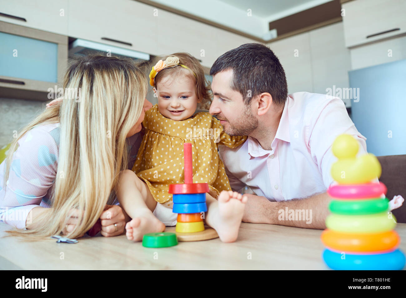 A family with child plays board games sitting at a table. Stock Photo
