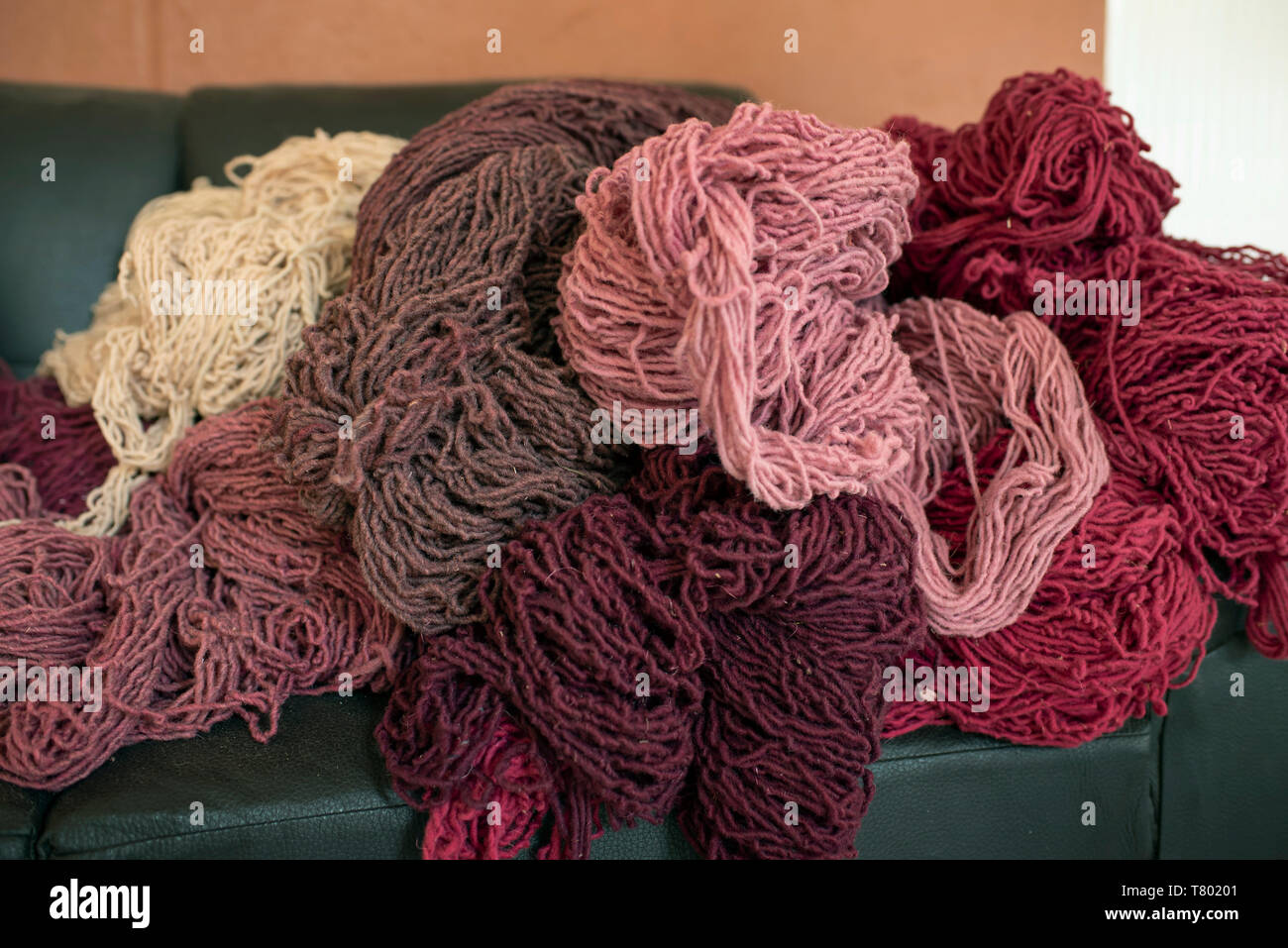 Woolen yarns ready to be woven. Different tones of natural red dye obtained from the cochineal insect. Teotitlán del Valle, Oaxaca, Mexico. Apr 2019 Stock Photo