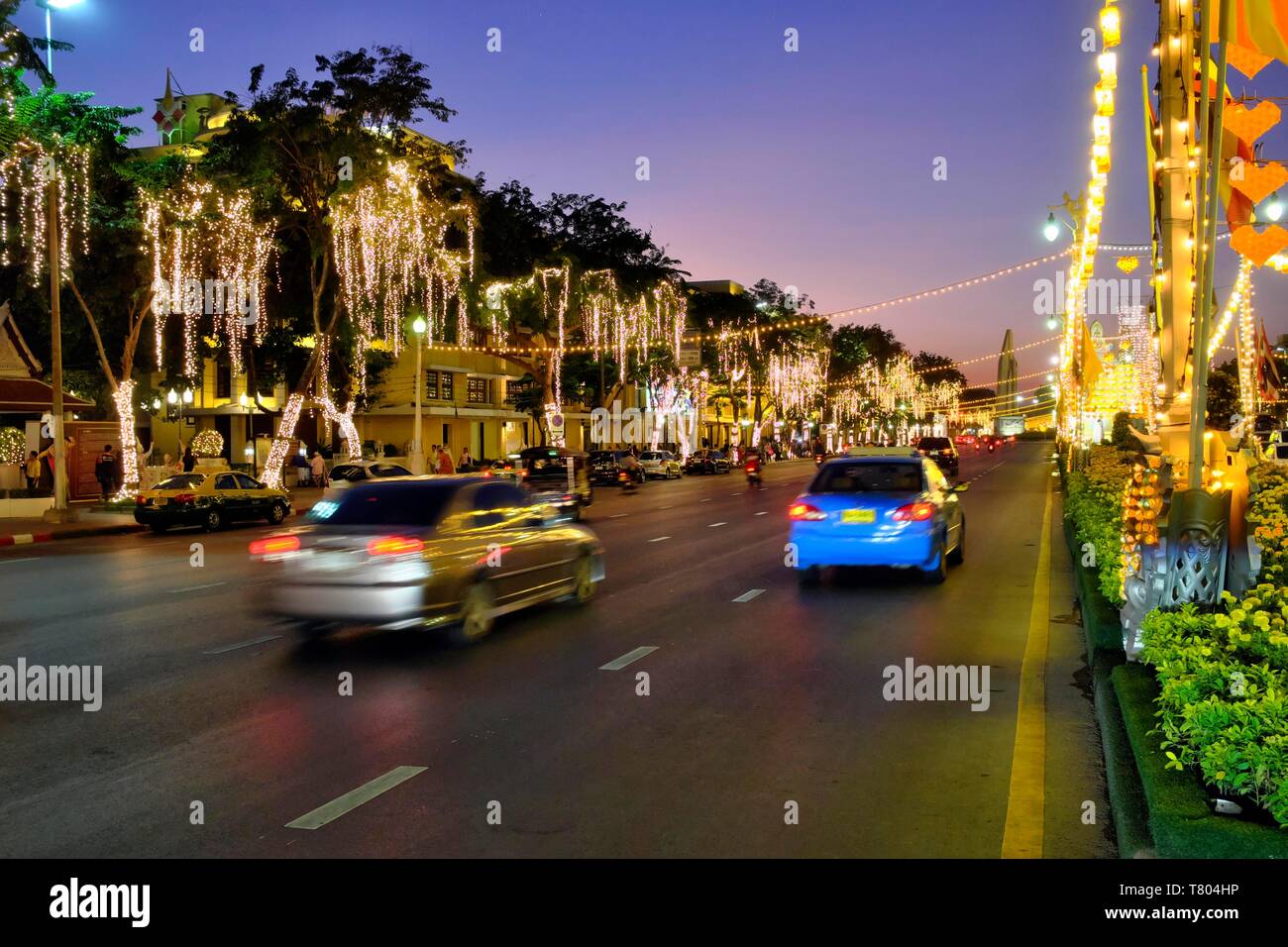 Illuminated street decorated with lights with car traffic at dusk, Rachadamnoen Klang Road, Bangkok, Thailand Stock Photo