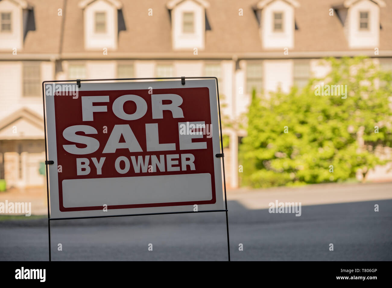 For sale by owner sign in front of a row of townhouses Stock Photo