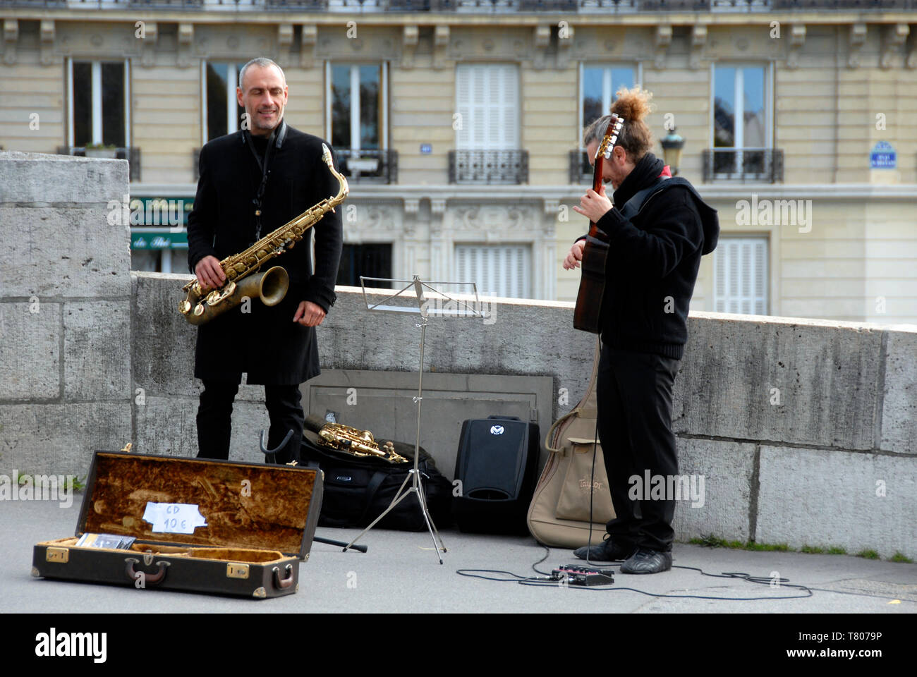 Two buskers performing in the street in Paris, France, with a variety of instruments and selling CDs Stock Photo