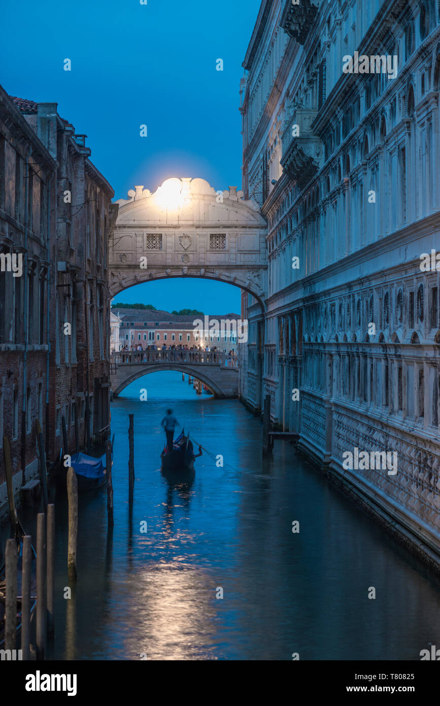 Gondolas pass under the Bridge of Sighs beside the Doges Palace in Venice at twilight, Venice, UNESCO World Heritage Site, Veneto, Italy, Europe Stock Photo