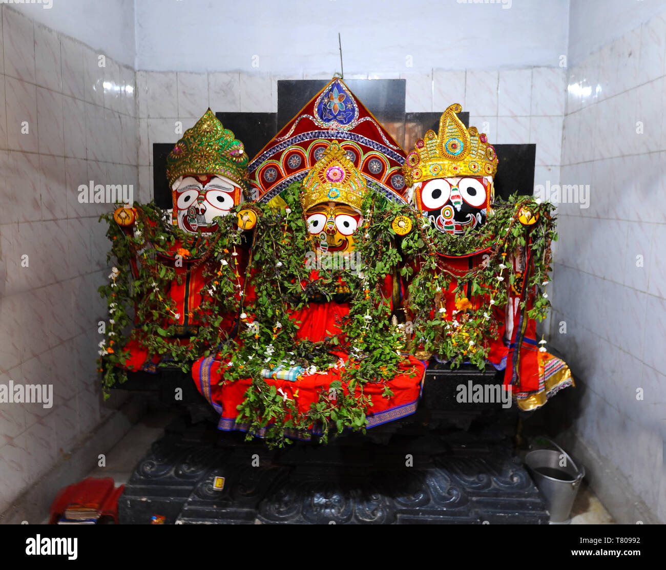 Trio of deities draped with leaf garlands inside temple to Lord Jagannath, rural Odisha, India, Asia Stock Photo