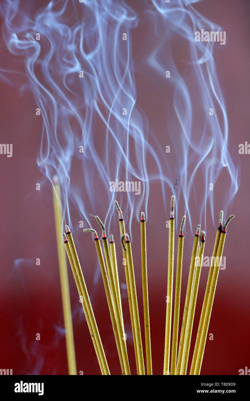 Incense sticks on joss stick pot burning, smoke used to pay respect to the Buddha, Vung Tau, Vietnam, Indochina, Southeast Asia, Asia Stock Photo