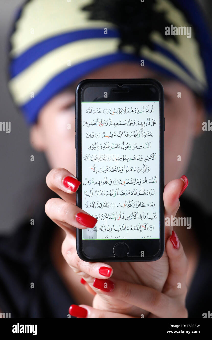 Woman with a digital Quran on a smartphone, Vietnam, Indochina, Southeast Asia, Asia Stock Photo