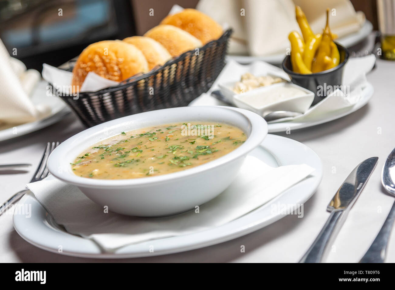 Traditional Balkan beef soup in Restaurant with garnish, peppers, bread Stock Photo