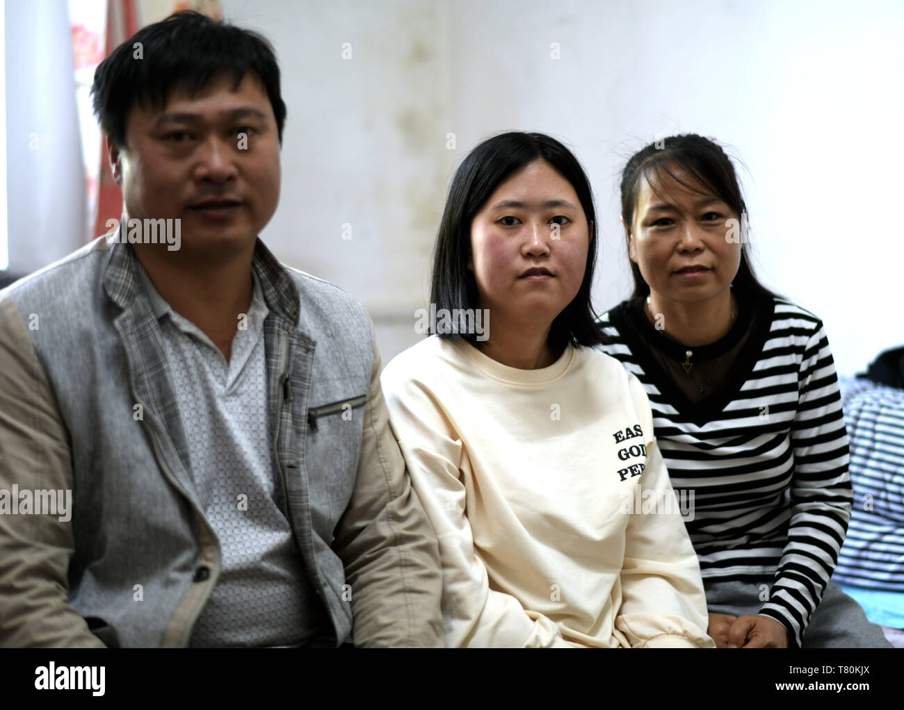 (190510) -- HARBIN, May 10, 2019 (Xinhua) -- Photo taken on May 9, 2019 shows Qin Tingting (C) and her parents in their residence in Harbin, northeast China's Heilongjiang Province. Qin Tingting, originally from north China's Inner Mongolia Autonomous Region, is a freshman of Harbin Engineering University. Suffering from Congenital Myasthenic Syndrome (CMS, also known as muscle weakness), she has to sit on a wheelchair and make much more effort than average people. After being diagnosed with CMS, Qin never gave up her dream that she wanted to get into university. She was admitted to the Colleg Stock Photo