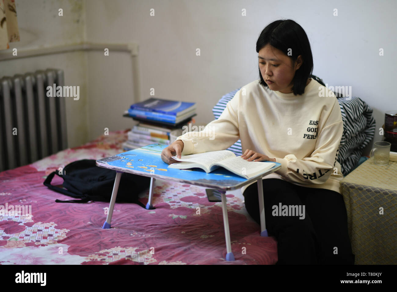 (190510) -- HARBIN, May 10, 2019 (Xinhua) -- Qin Tingting studies at her residence in Harbin, northeast China's Heilongjiang Province, on May 9, 2019. Qin Tingting, originally from north China's Inner Mongolia Autonomous Region, is a freshman of Harbin Engineering University. Suffering from Congenital Myasthenic Syndrome (CMS, also known as muscle weakness), she has to sit on a wheelchair and make much more effort than average people. After being diagnosed with CMS, Qin never gave up her dream that she wanted to get into university. She was admitted to the College of Materials Science and Chem Stock Photo