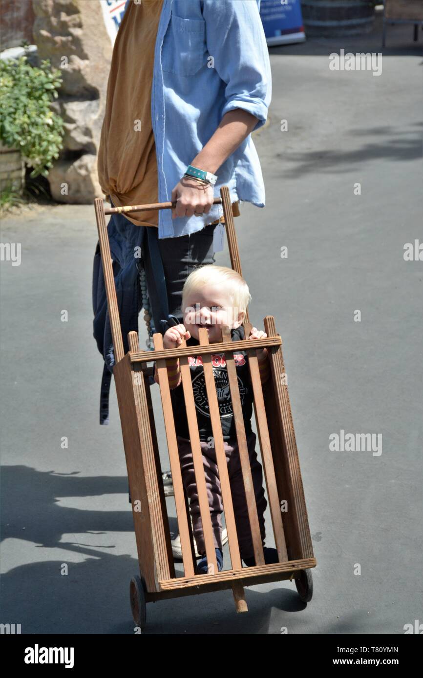 Real toddler boy riding in mom's shopping cart at a street fair in ...