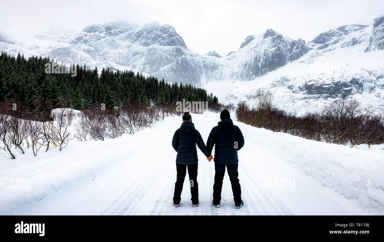 At 68 Degrees North, a couple consider Arctic Winter landscape of Lofoten, Nordland, Norway, Europe Stock Photo