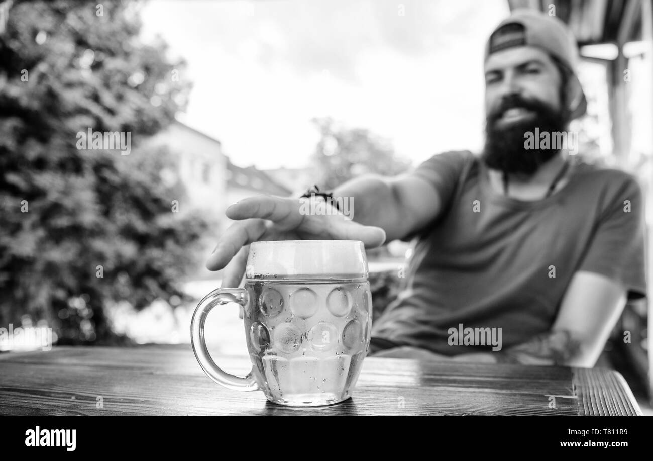 Enjoying non alcoholic beer. Bearded man grabbing alcoholic drink in bar. Hipster sitting with alcoholic beverage in pub. He is a social drinker not an alcoholic. Stock Photo