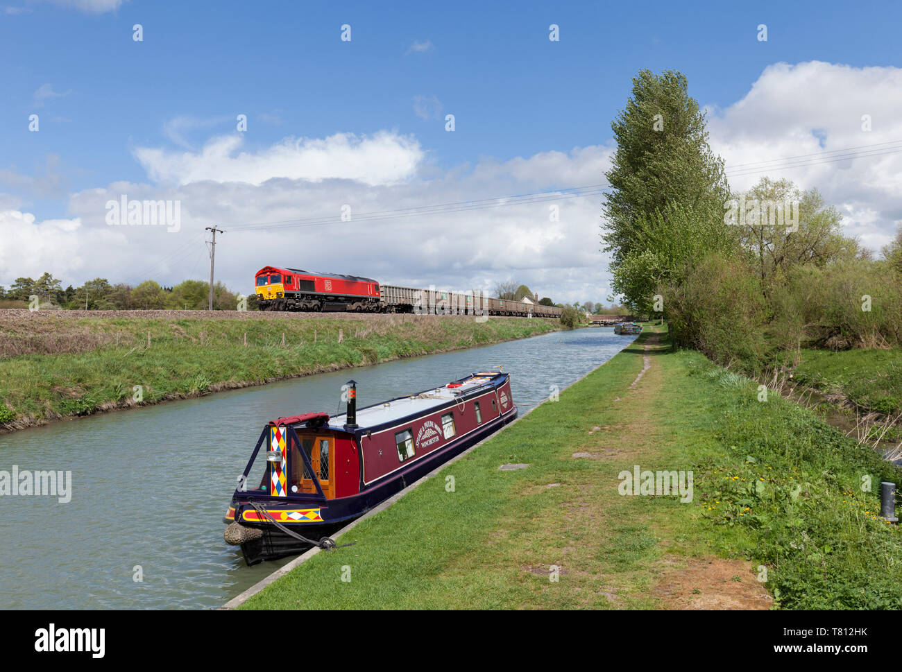 DB Cargo class 66 diesel locomotive passing the Kennet and Avon canal at Crofton, Wiltshire with a freight train of empty aggregate wagons Stock Photo