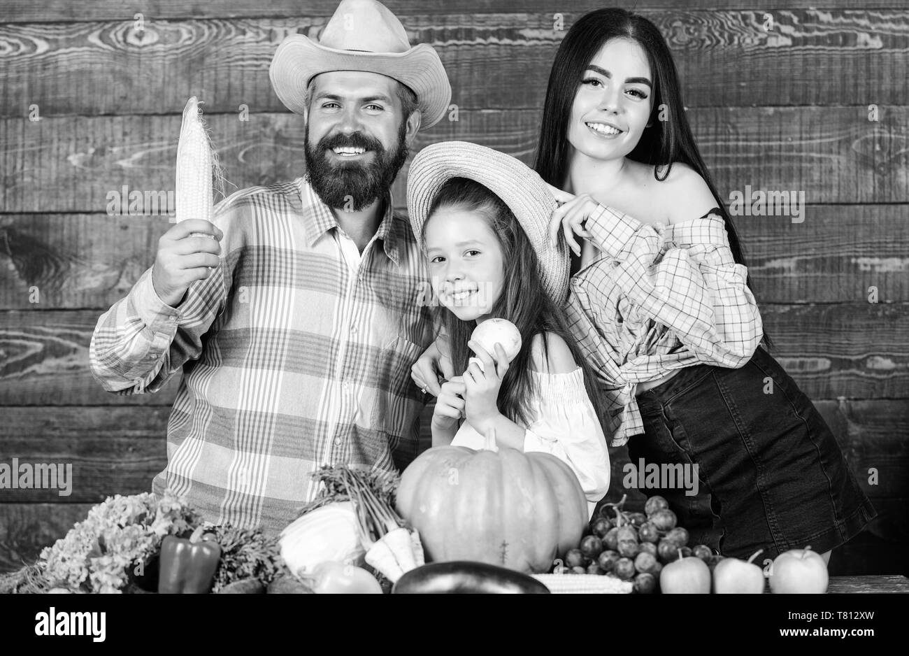 Family farm concept. Family farmers with harvest wooden background