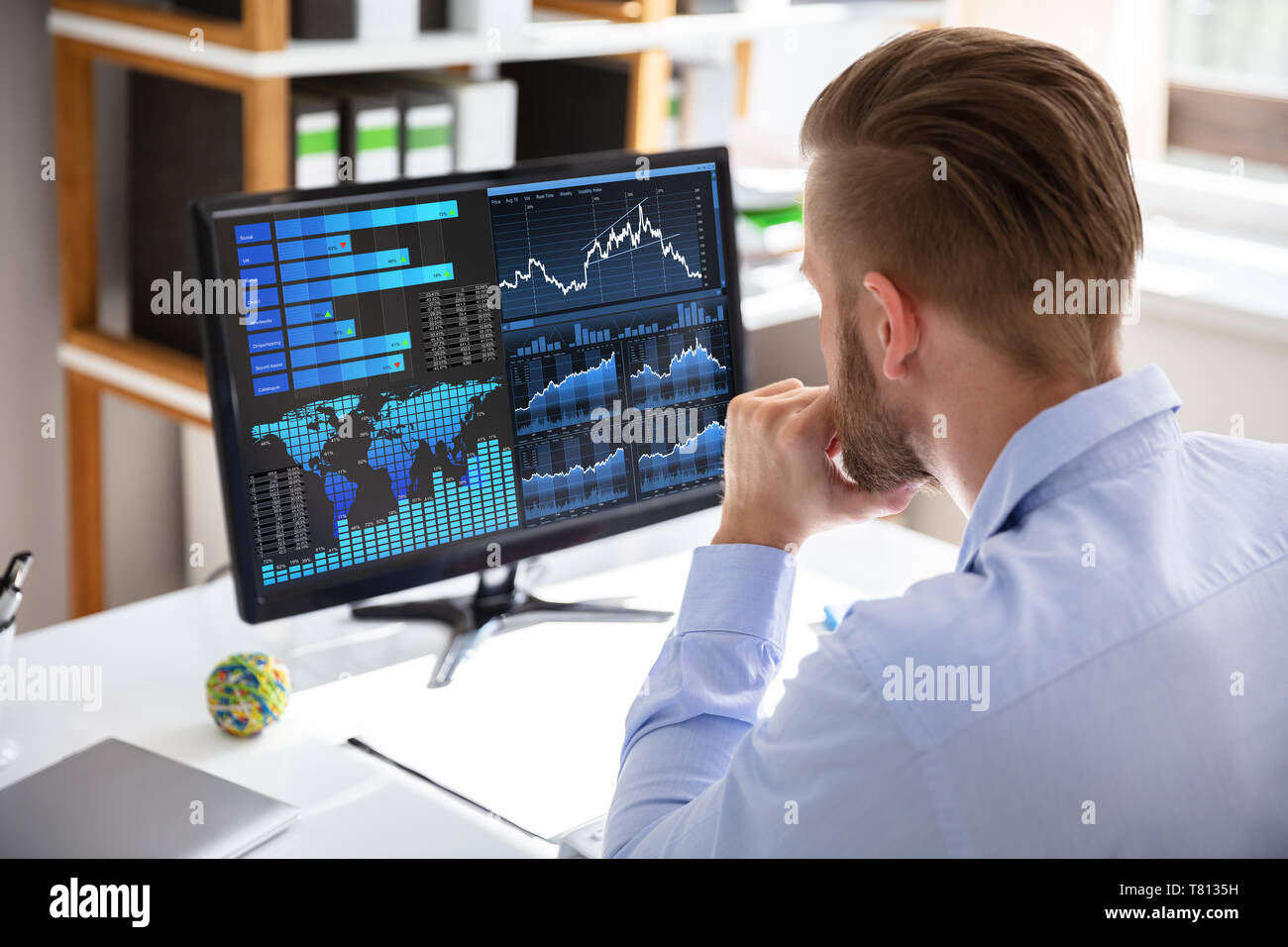 Businessman Looking At Dashboard Analyzing KPI Graph On Computer Stock Photo
