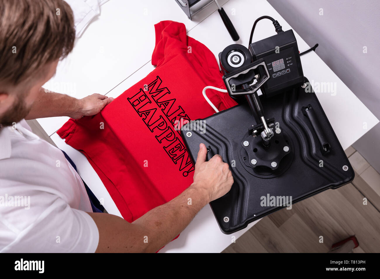 Man printing on t shirt in workshop Stock Photo