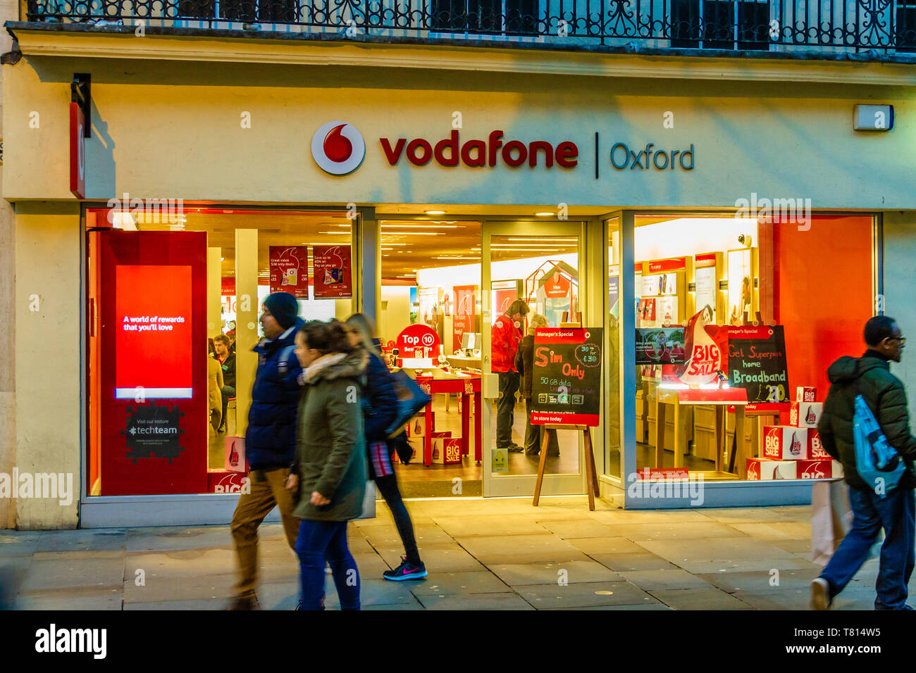 People passing a Vodafone shop front in Oxford, UK. December 2018. Stock Photo