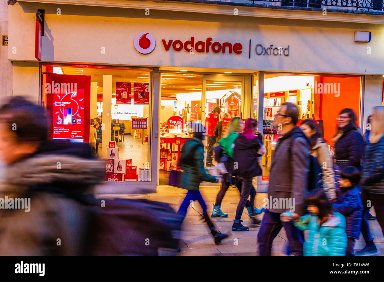 People passing a Vodafone shop front in Oxford, UK. December 2018. Stock Photo
