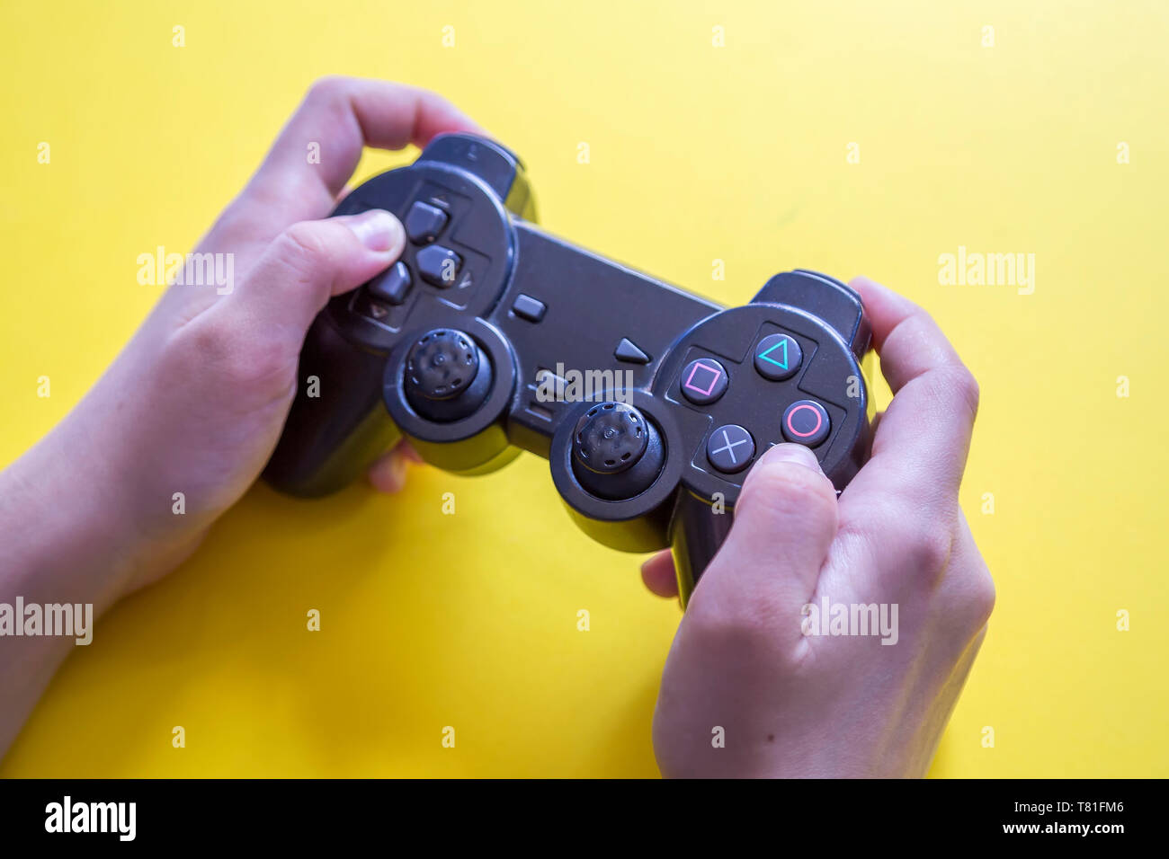 Gamer holding video games gaming controller on yellow background Stock Photo