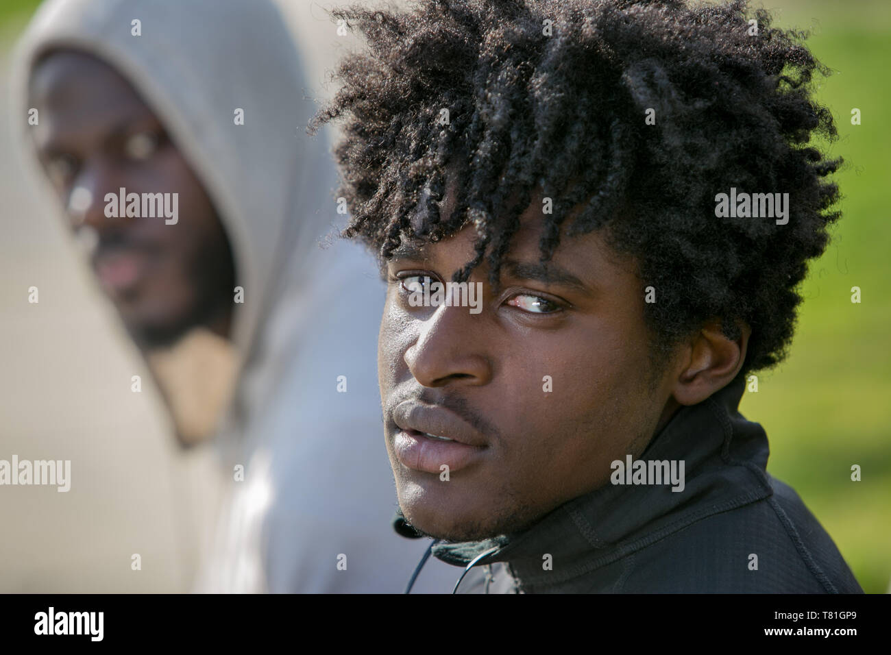 street portrait taken in Philadelphia Pennsylvania of 2 African American friends in a park Stock Photo