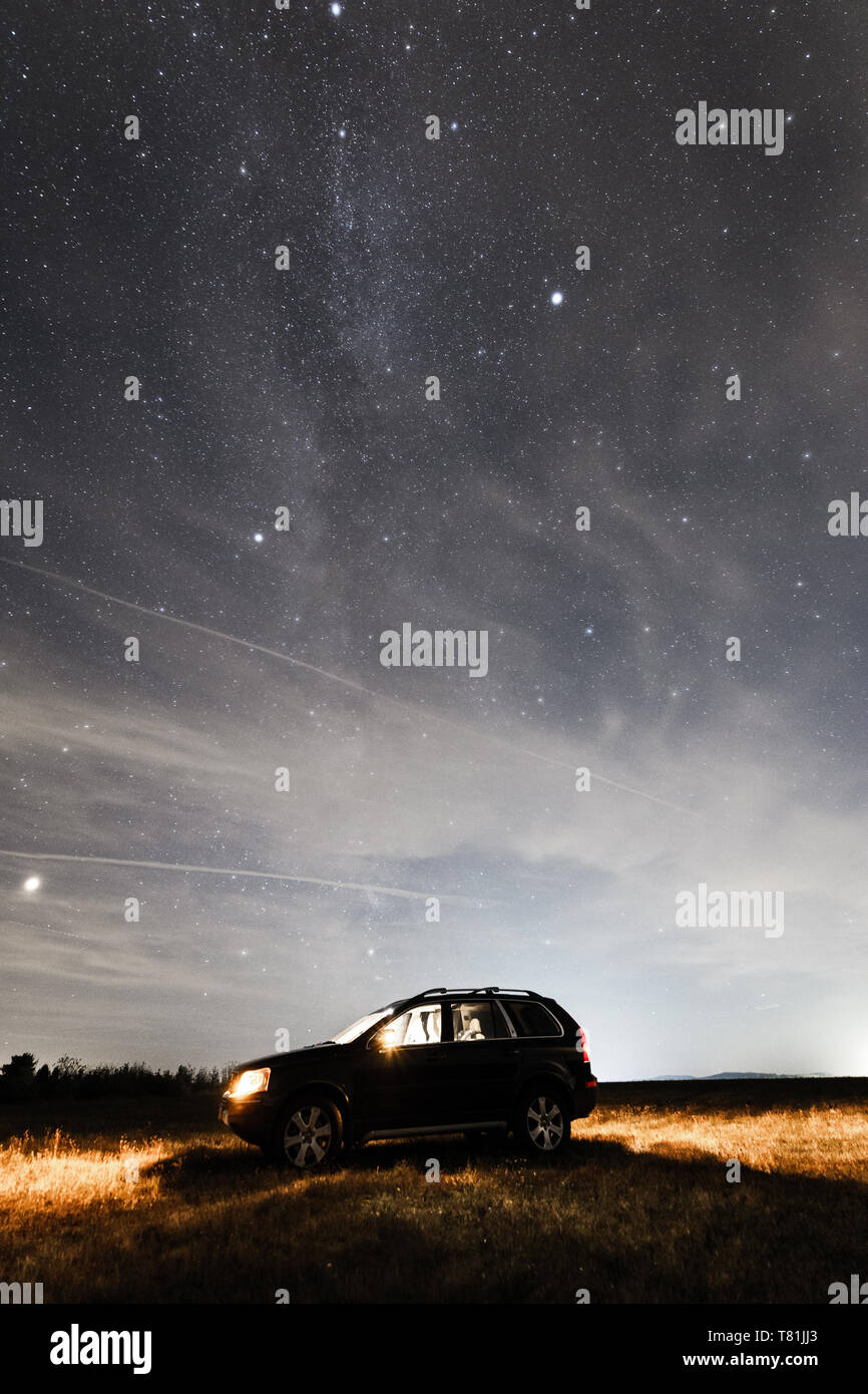 An off-road vehicle under a starry sky, Milky Way Stock Photo