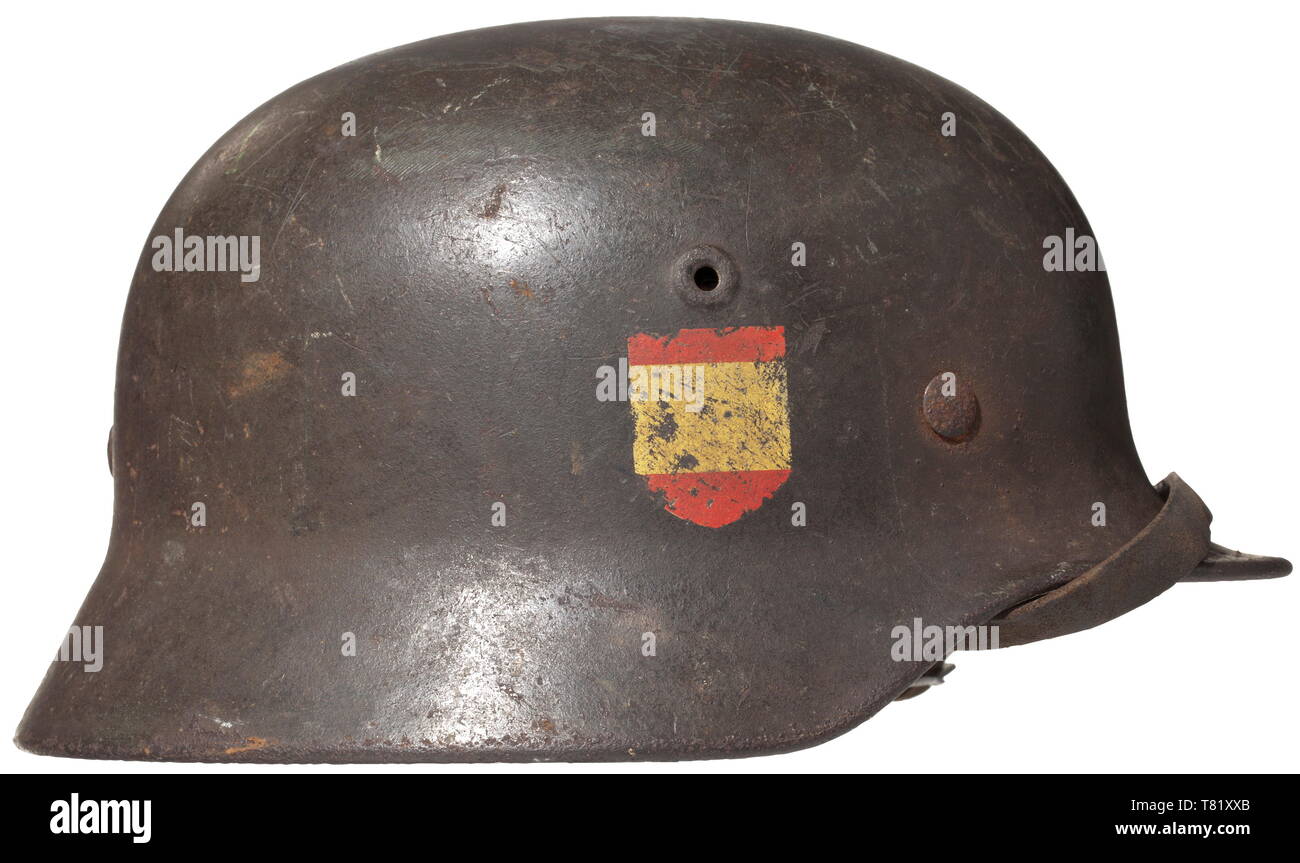 A steel helmet M 40 for 'Blue Division' members - 'Division Espanola de Voluntarios'. Field-grey painted steel shell (rust pitted), the eagle shield up to 60% intact, the troop recognition symbol on the right side in the Spanish national colours up to 80% intact. The shell interior with maker's mark 'Q 64' of the Quist firm, Esslingen. Complete inner liner with chin strap. historic, historical, army, armies, armed forces, military, militaria, 20th century, Editorial-Use-Only Stock Photo