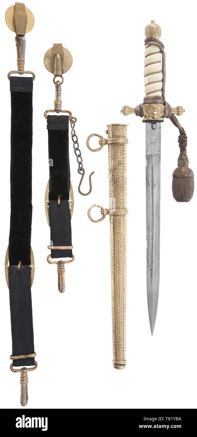 A dagger M29 for officers, with portepee and hanger, Maker Alcoso, Solingen. Plated blade with etched fouled anchor and sailing ships amid tendrils, stamped manufacturer's trademark on the ricasso (traces of age). Pommel, cross-guard and push button release with most gilding intact. White-coloured grip with wire wrap. Gilt scabbard with hammered pattern. Length 40 cm. Toned silver portepee, black ribbed silk hanger with black velvet liner and gilt fittings. USA-lot historic, historical, navy, naval forces, military, militaria, branch of service, branches of service, armed f, Editorial-Use-Only Stock Photo