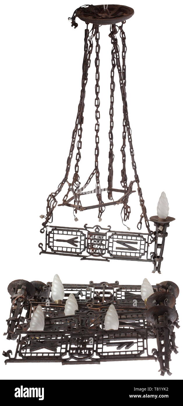 A ceiling light with runes and motto, six-armed, cast iron with hand-forged elements, the interstices with runes and banderoles 'Treue um Treue' and 'Meine Ehre heißt Treue'. The individual pieces elaborately decorated, and held together by means of screws and pins. Six post-war 110-volt light bulbs enclosed. Not checked for functionality, electrical installation must be renewed by a professional. Arm dimensions ca. 55 x 24 cm. The consignor states the object comes from a graduate of the Bad Tölz Junker school. Outstanding craftmanship, age marks, not mounted. Very rare. hi, Editorial-Use-Only Stock Photo