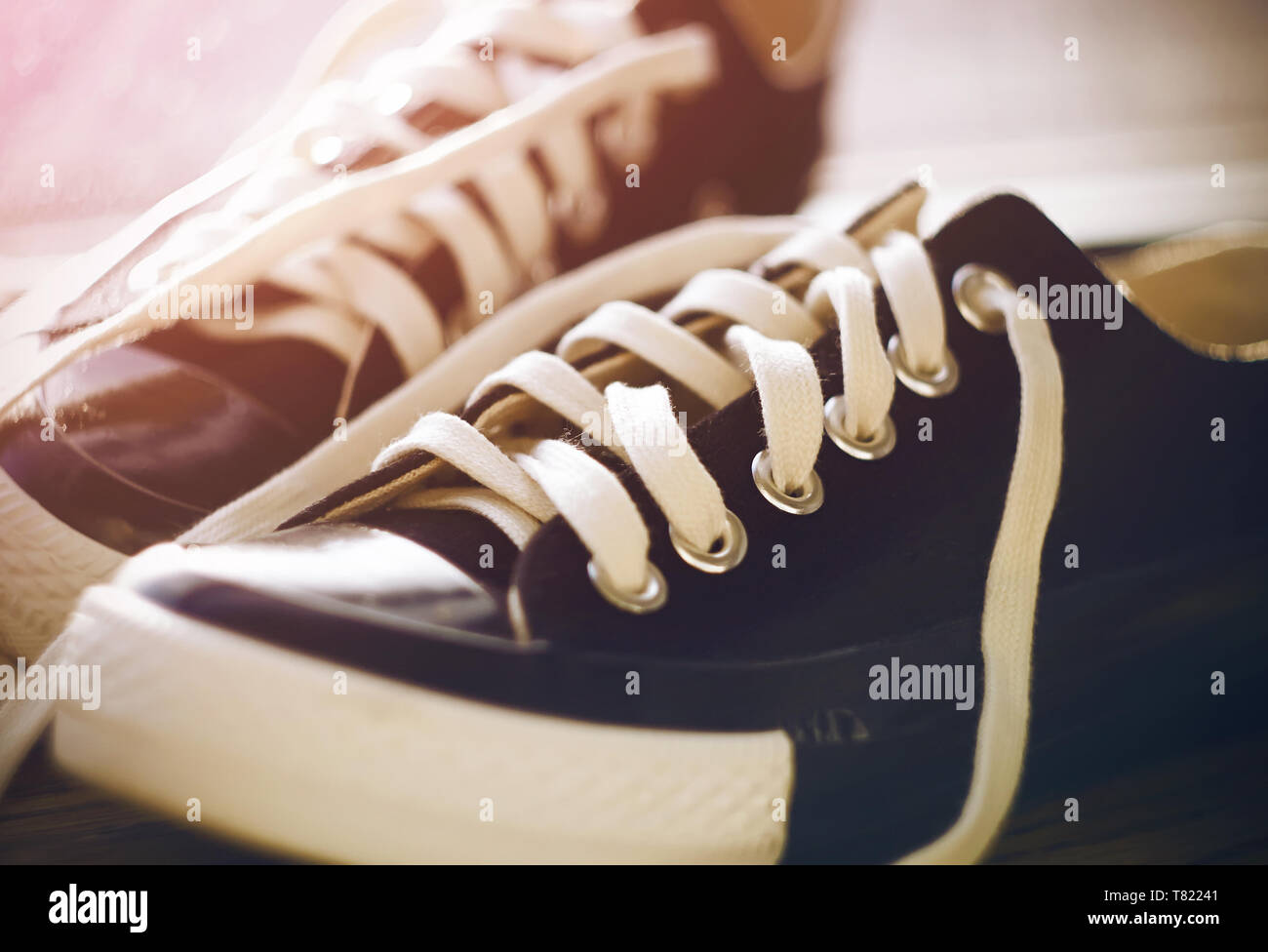 Black classic sports shoes with untied laces lie in the hallway