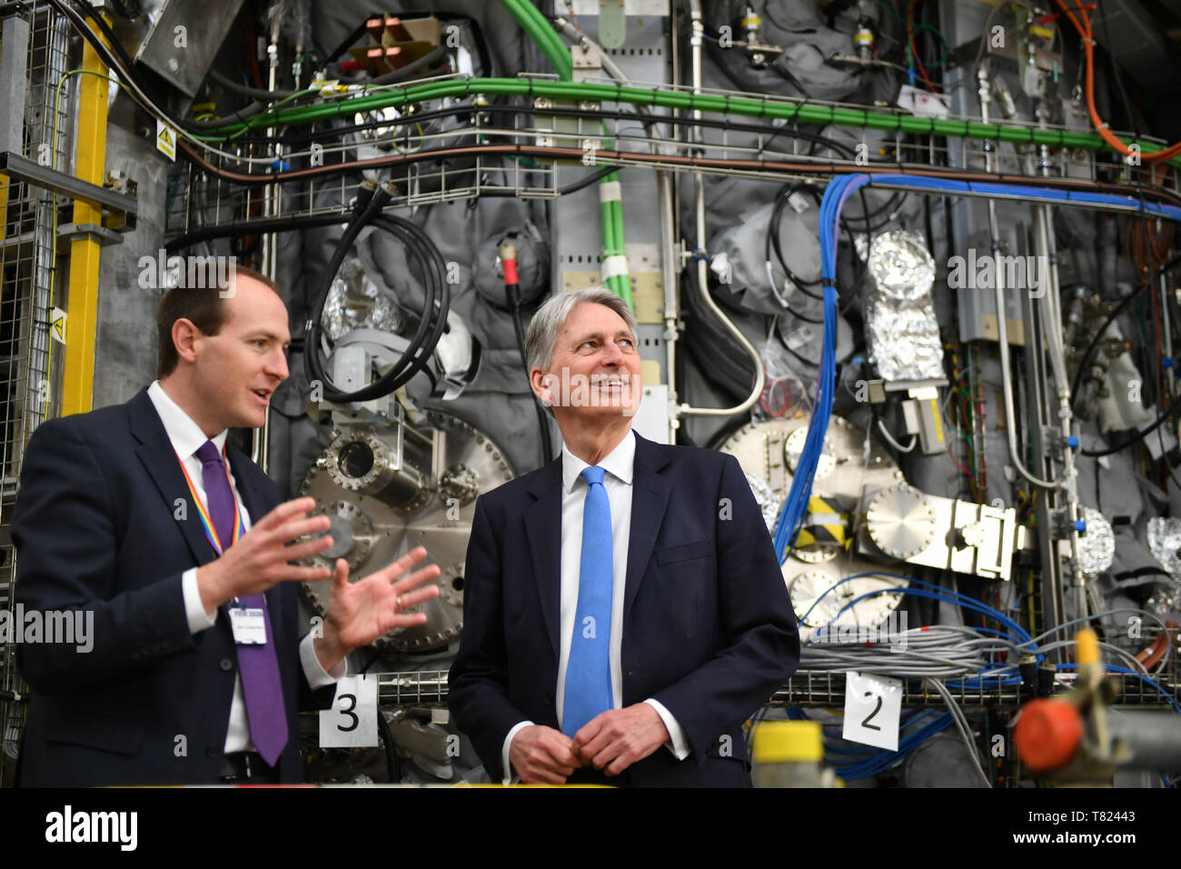 Chancellor Philip Hammond speaking to Ian Chapman, Chief Executive of the UK Atomic Energy Authority, in front of nuclear infusion scientific equipment, as he marks the publication of the UK gross domestic product (GDP) first quarterly estimate during a visit to the Culham Science Centre in Abingdon, Oxfordshire. Stock Photo