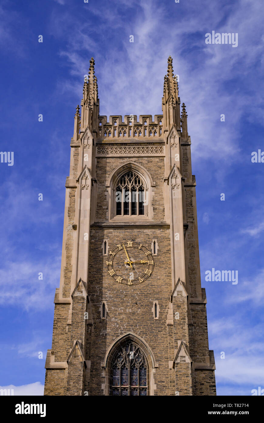 Gothic tower in front of bright blue sky with white cirrus clouds Stock ...