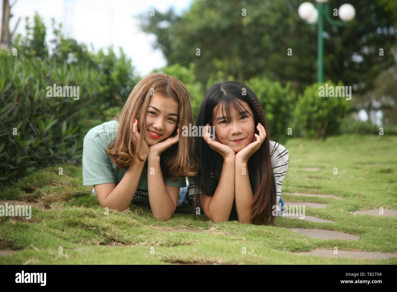 photo of two girls lying on a grass Stock Photo