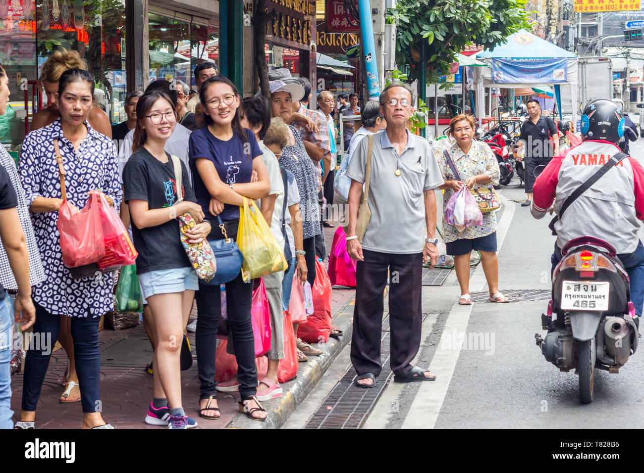 Bangkok, Thailand - 1st August 2017 -  People waiting for a bus in Chinatown.  This one of the busiest areas of the city. Stock Photo