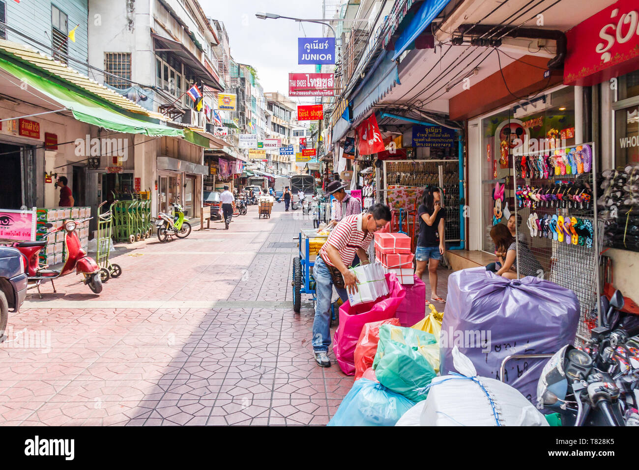 Bangkok, Thailand - April 21st 2011. Man packing boxes. This is a typical street in Chinatown. Stock Photo