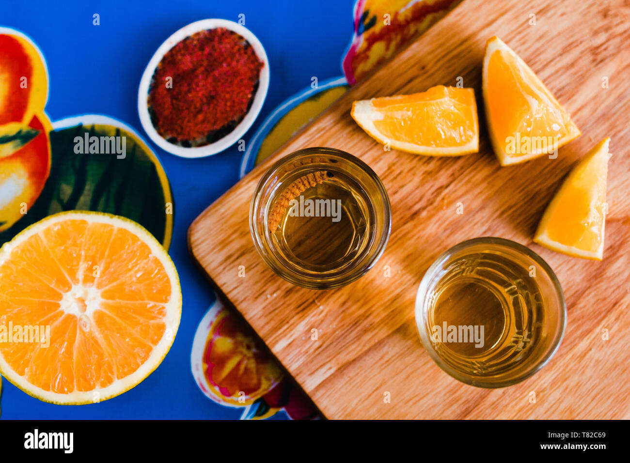 mezcal shot with chili salt, agave worm and orange, mexican drink in