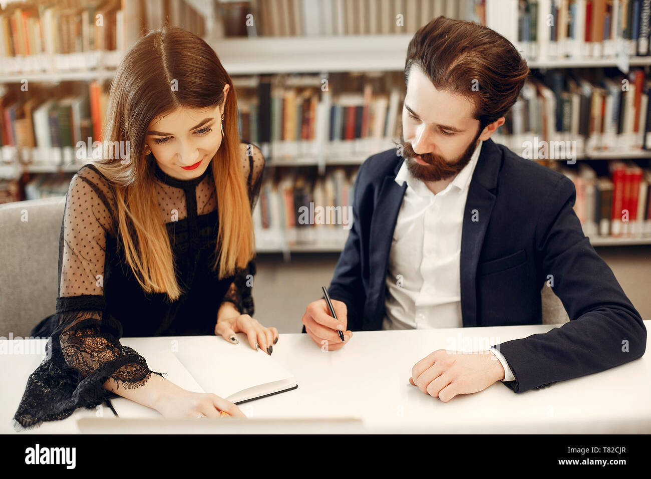 Library Guy Students in a library. Guy in a black suit. Student with a books Stock ...