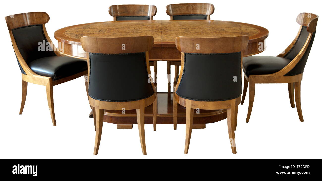 Paul Ludwig Troost - dining room group, model no. 84 Excellently manufactured furniture by the Vereinigte Werkstätten für Kunst und Handwerk, Munich. Comprising six chairs and one oval extension dining table. Size of the latter 77 x 178 x 119 cm, model no. 51249, of cherry wood and Caucasian walnut veneer. The bottom with a plaque of the Vereinigte Werkstätten and stamp '449 V.W. 23 51249'. Sizes of the chairs 50/88 x 53 x 61 cm, model no. 50767, one chair marked '352 V.W. 4 50767', same types of wood as table. The synthetic le 20th century, Editorial-Use-Only Stock Photo