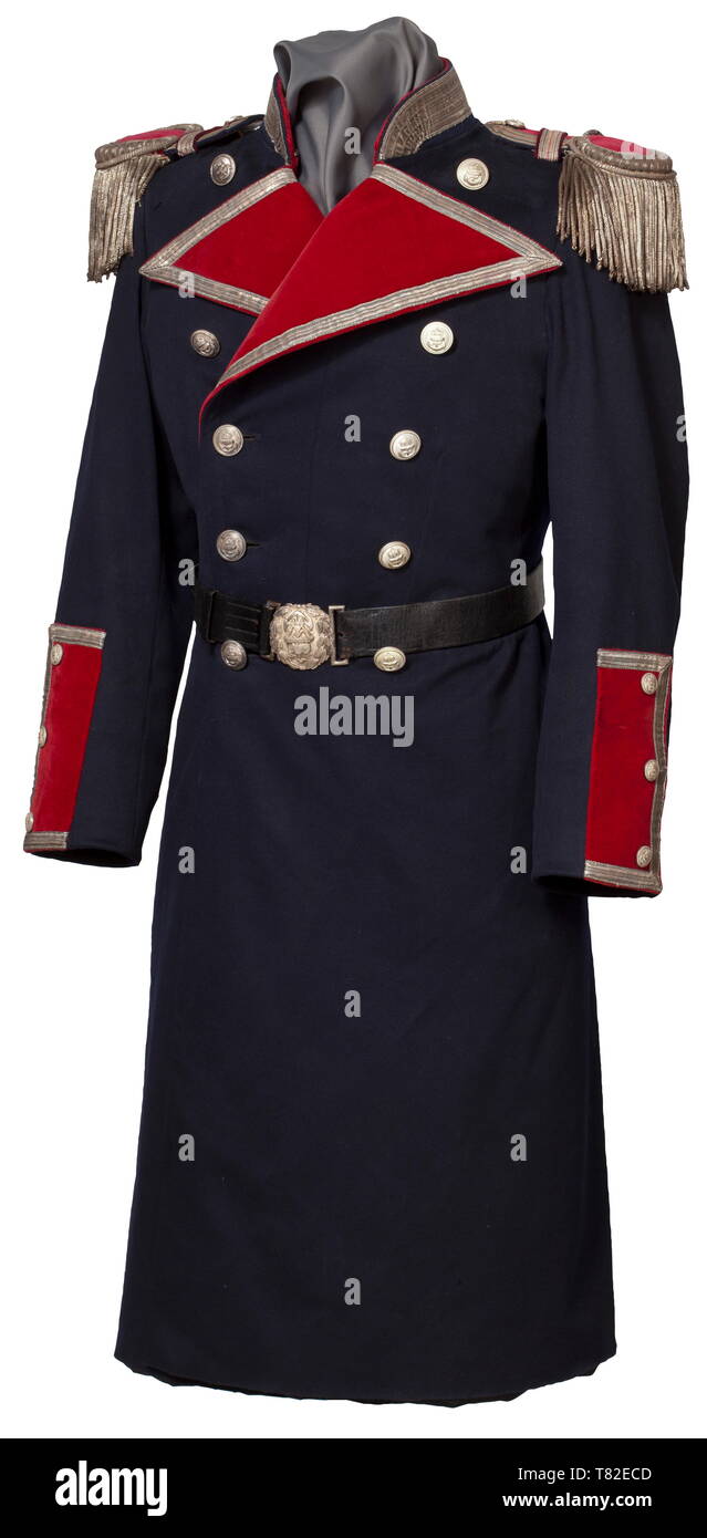A long coat for the dress uniform of a naval court martial council Dark blue cloth with crimson piping, silver buttons and braid, the epaulettes with crimson velvet fields (insignia removed), silver braid with black-red interweave, silver-wrought crescents and silver fringes. Black silk liner. Included is a black leather belt with silver buckle. Slight damage in places, traces of age. Extremely rare. historic, historical, navy, naval forces, military, militaria, branch of service, branches of service, armed forces, armed service, object, objects,, Additional-Rights-Clearance-Info-Not-Available Stock Photo