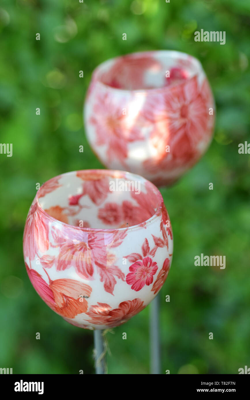 floral patterned glass candle holders in garden Stock Photo Alamy