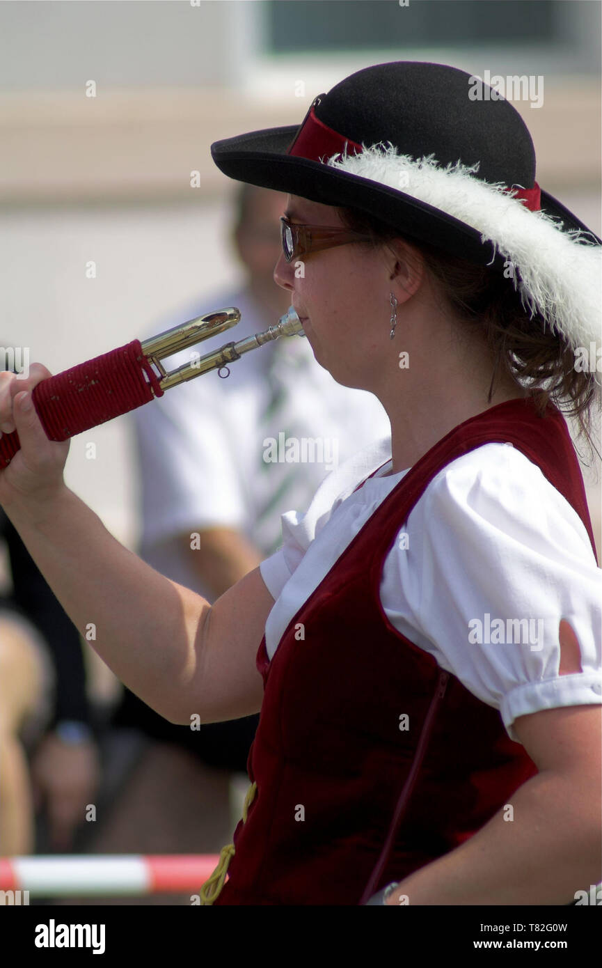 A woman in a hat with a feather playing the signal trumpet. Eine Frau in einem Hut mit einer Feder, welche die Signaltrompete spielt Gra na sygnałówce Stock Photo