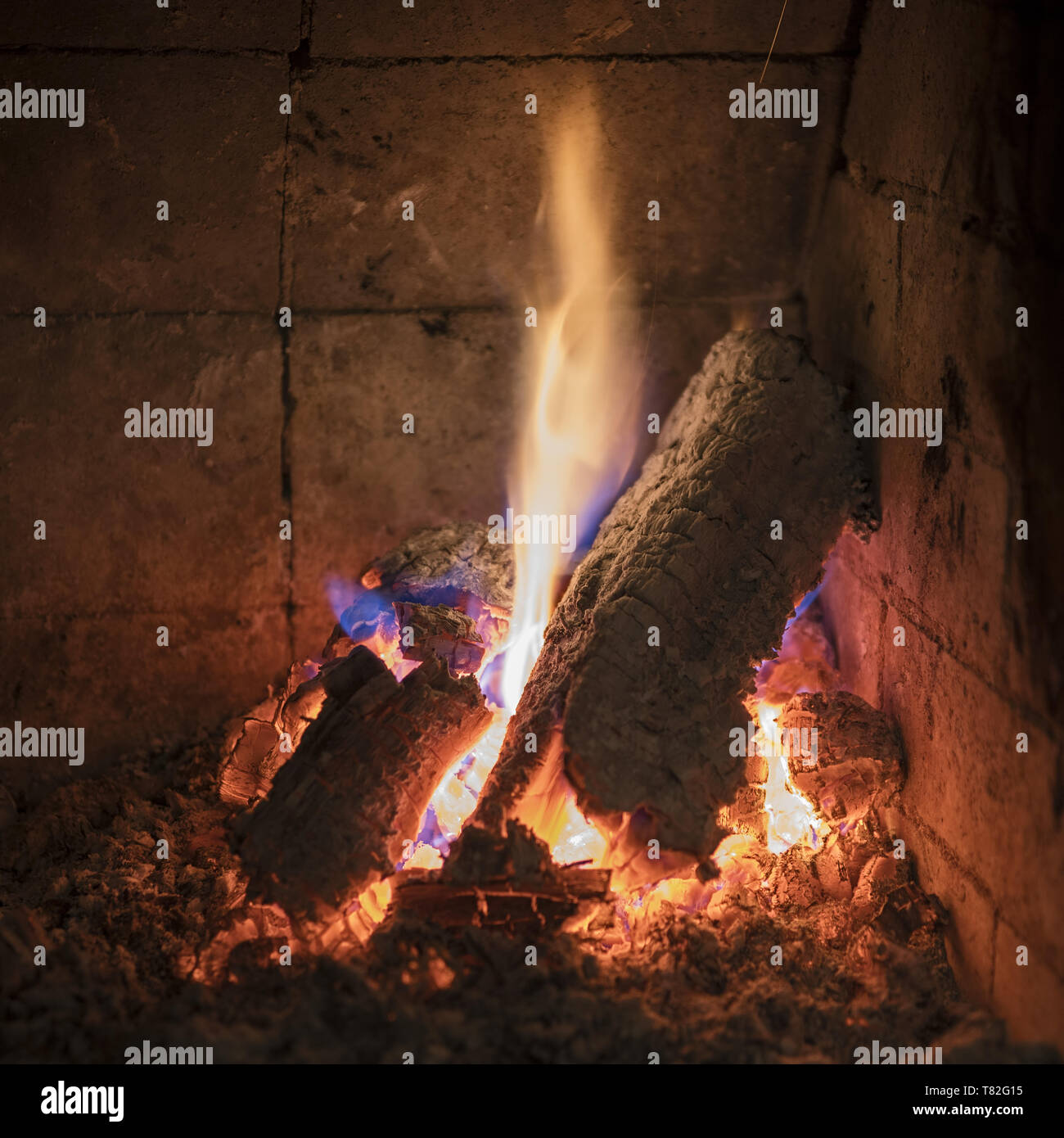 Burning logs, pieces of wood in the fireplace. Brennende Holzscheite, Holzstücke im Kamin. Płonące polano, kawałki drewna w kominku. Stock Photo