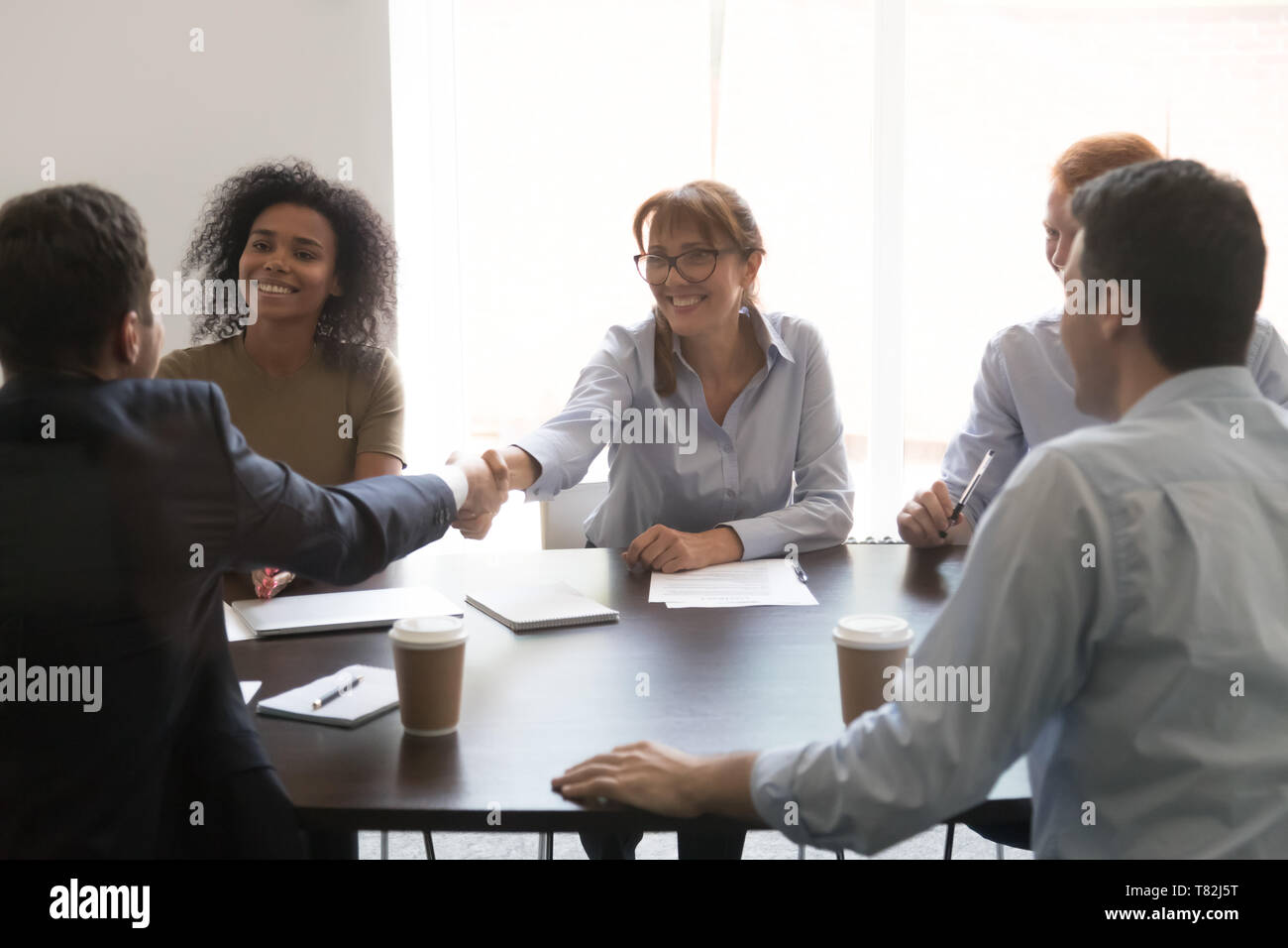 Businesspeople handshake at meeting congratulating with successful negotiations Stock Photo