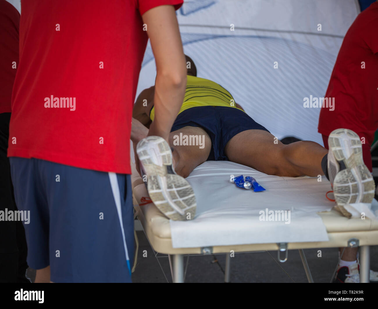 Athlete lying on a Bed while having Legs Massaged after a Physical