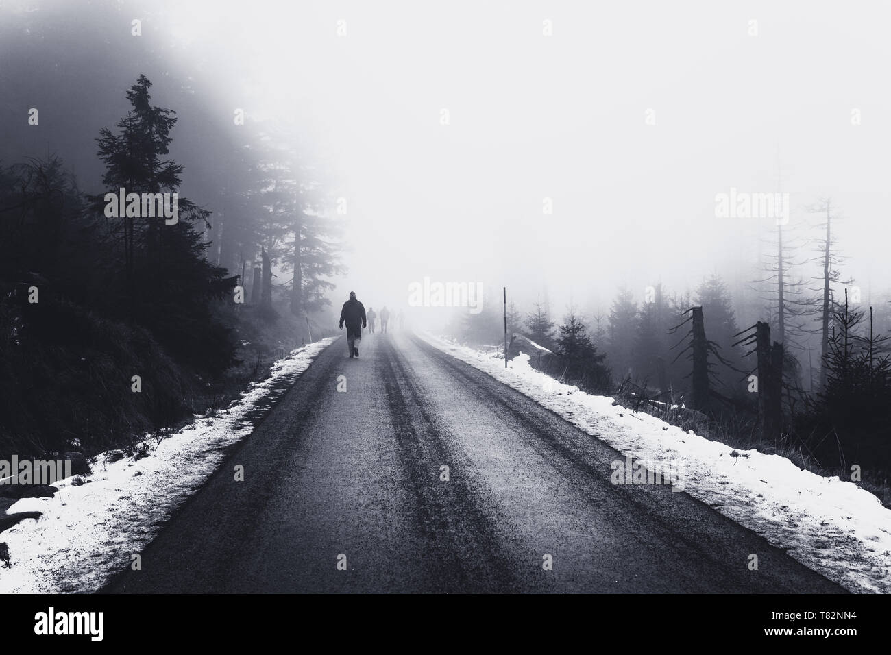 Lonely man running on icy road towards fog Stock Photo
