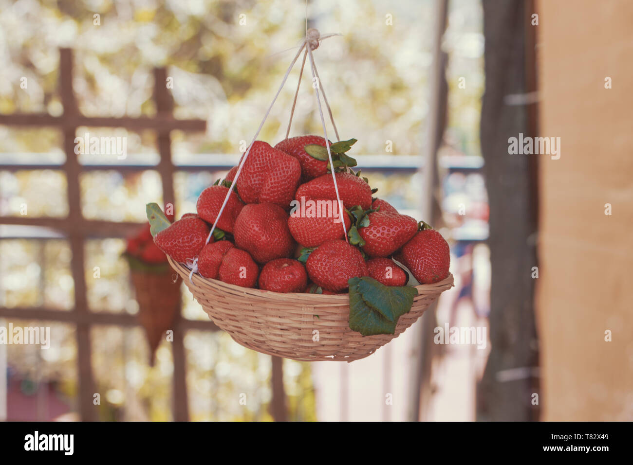 Fresh red tasty strawberries in basket outdoors, cinematic style, color graded Stock Photo
