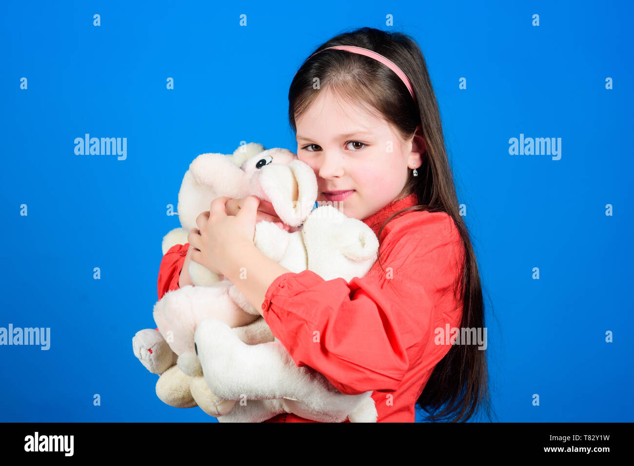 Collecting toys hobby. Cherishing memories of childhood. Small girl smiling face with toys. Happy childhood. Little girl play with soft toy teddy bear. Lot of toys in her hands. Childhood concept. Stock Photo