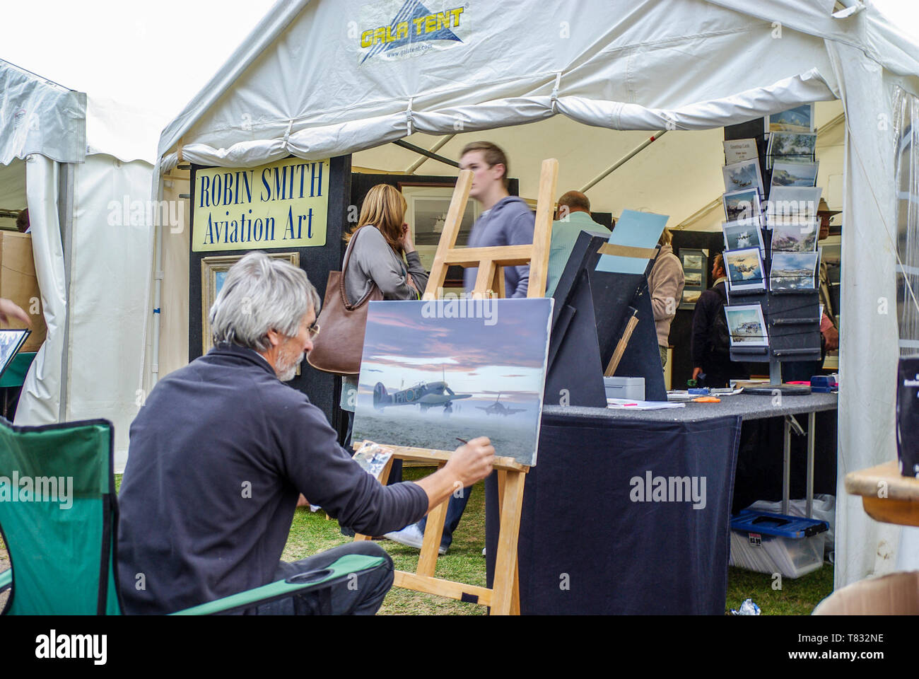 Robin Smith Aviation Art artist working on a painting outside his sales tent at an airshow. Painting titled Another Dawn, RAF Typhoon second world war Stock Photo