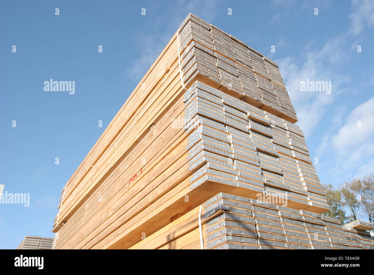 Stacks of new scaffolding boards in a London Builders Merchant's yard. Photographed on a sunny, summer day. Stock Photo